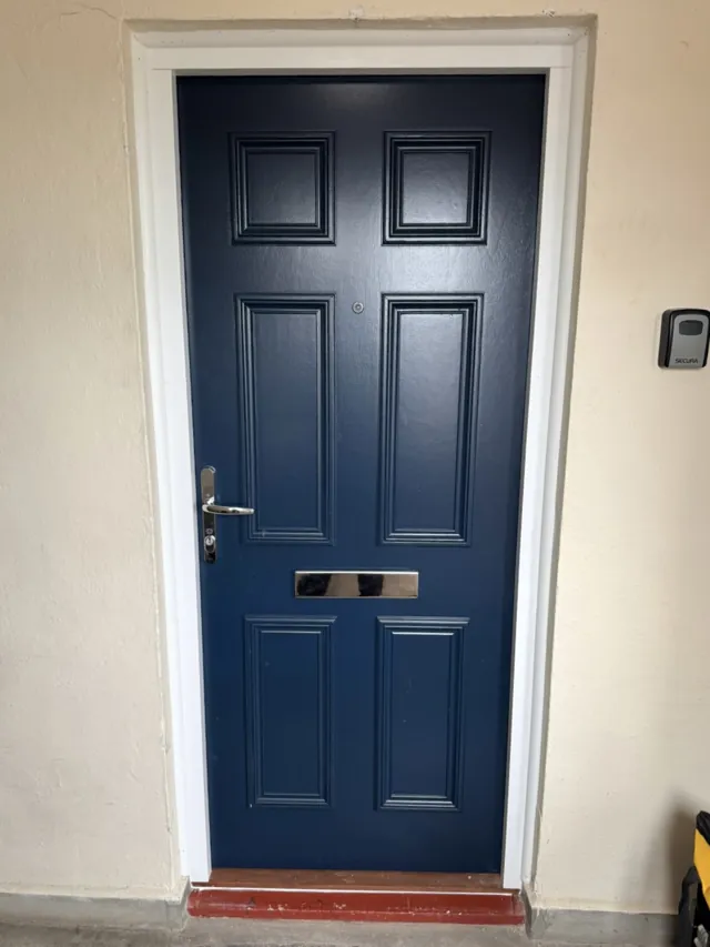 Navy panelled entrance door with letterplate and matching frame