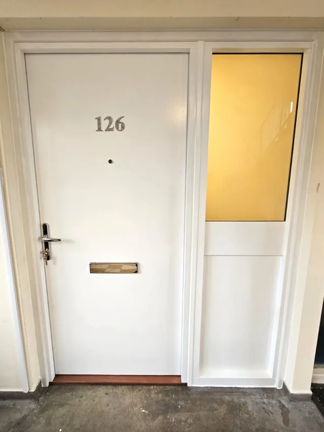White entrance door with letterplate and adjacent glazed panel