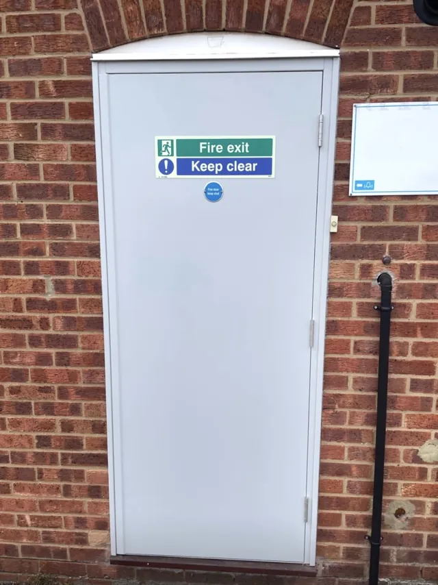 White exterior single door set within a brick opening