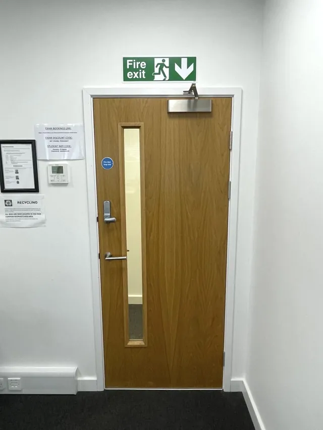 Timber single door with a narrow vision panel beside wall controls